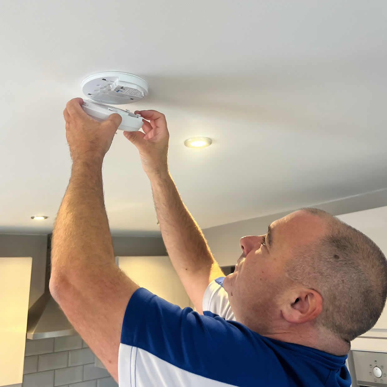 Smoke alarm being installed on a ceiling in Cheltenham